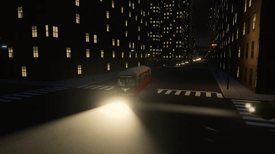 A PCC with its headlight on crossing a downtown street at night between office buildings with lit windows