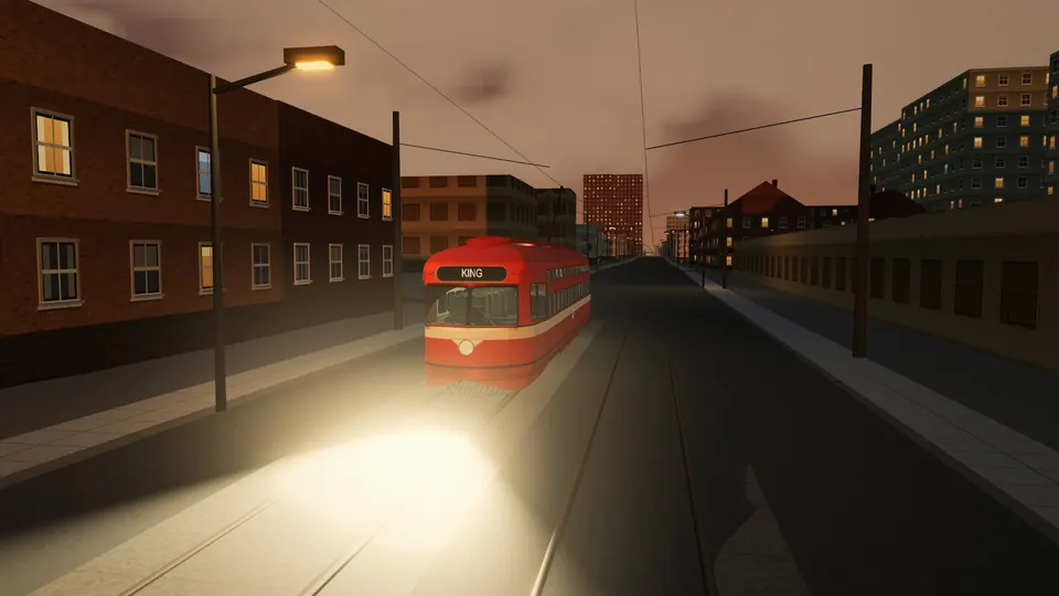 A red Toronto PCC car with its headlight on, coming down King Street at dusk