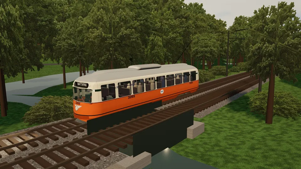 An orange and cream MBTA PCC car crossing a small bridge among trees on the Mattapan line